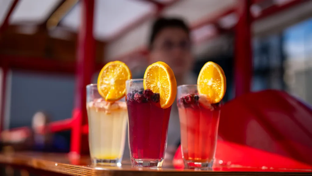 Three homemade fruit lemonades with orange slices served on board a red Bratislava Bike Tour vehicle